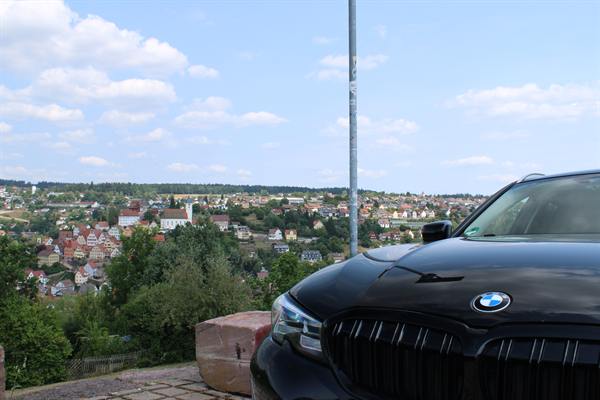 BMW mit Panoramablick über eine Stadt im Hintergrund